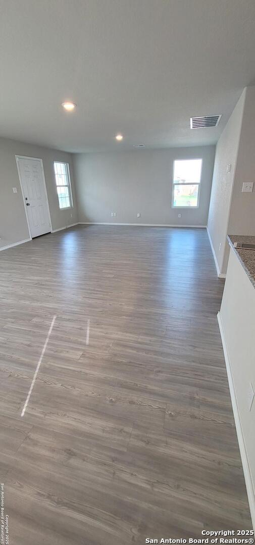 10814 Prusiner, Converse, TX 78109 - unfurnished living room featuring baseboards, wood finished floors, and recessed lighting