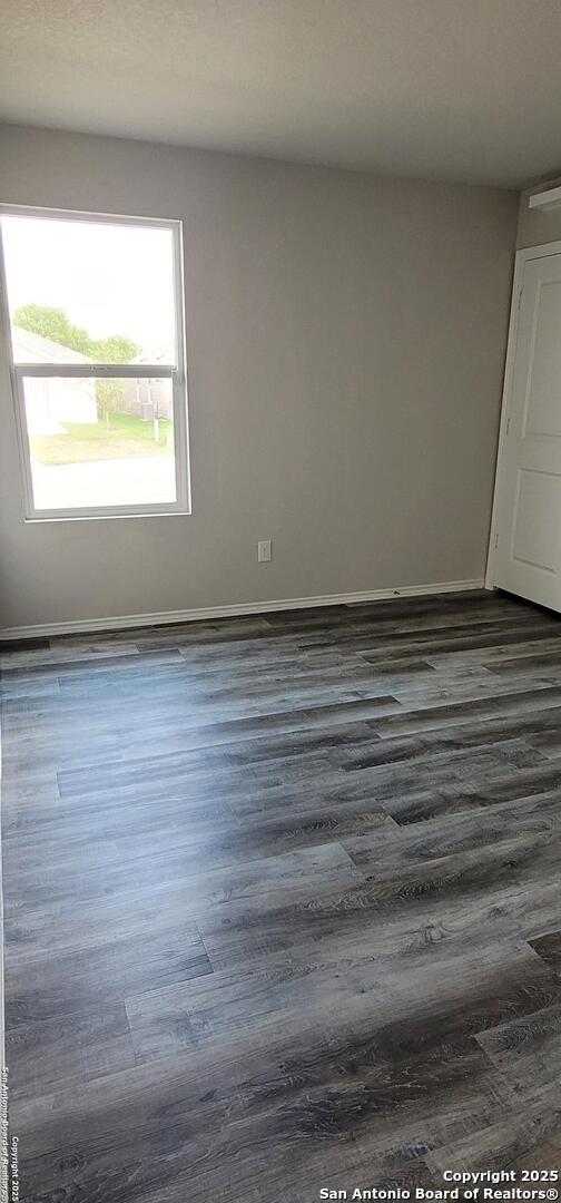 10814 Prusiner, Converse, TX 78109 - empty room with dark wood finished floors and baseboards