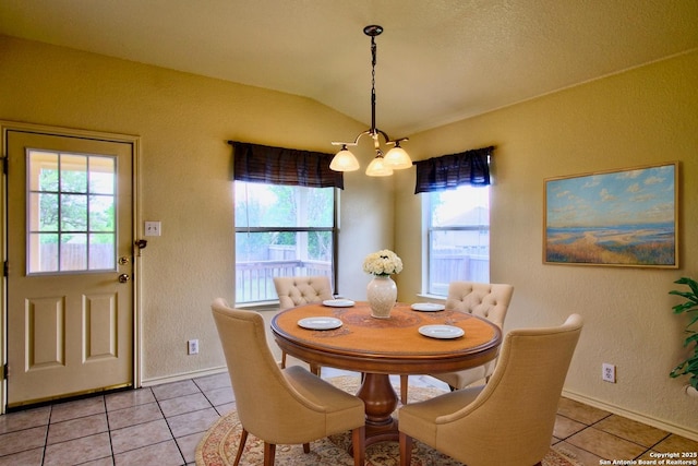 219 Starling, New Braunfels, TX 78130 - dining space featuring a chandelier, light tile patterned floors, a textured wall, vaulted ceiling, and baseboards