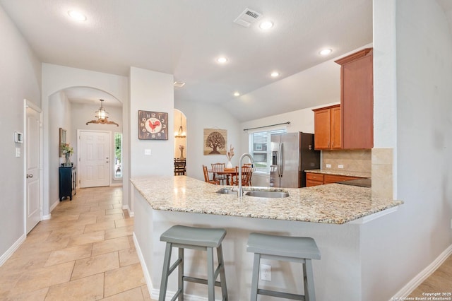 1926 Kalli Jo Ln, New Braunfels, TX 78130 - kitchen featuring arched walkways, stainless steel refrigerator with ice dispenser, a sink, baseboards, and brown cabinetry
