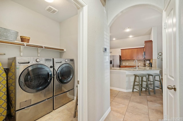 1926 Kalli Jo Ln, New Braunfels, TX 78130 - laundry room featuring washing machine and clothes dryer, arched walkways, light tile patterned flooring, and baseboards
