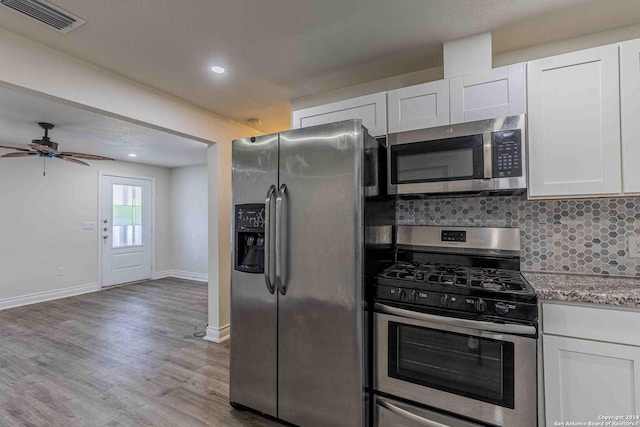 1309 Quintana Rd, San Antonio, TX 78211 - kitchen with appliances with stainless steel finishes, white cabinets, ceiling fan, baseboards, and wood finished floors