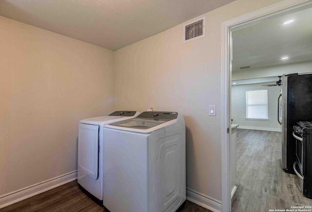 1309 Quintana Rd, San Antonio, TX 78211 - laundry area featuring independent washer and dryer, wood finished floors, and baseboards