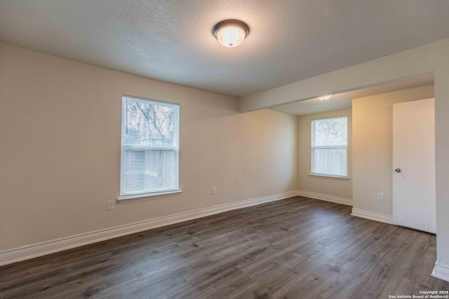 1309 Quintana Rd, San Antonio, TX 78211 - empty room with dark wood-type flooring, baseboards, and a textured ceiling