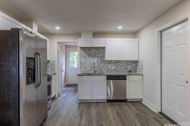 1309 Quintana Rd, San Antonio, TX 78211 - kitchen with stainless steel appliances, a sink, white cabinets, backsplash, and recessed lighting
