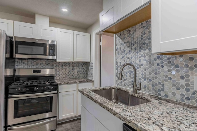 1309 Quintana Rd, San Antonio, TX 78211 - kitchen featuring stainless steel appliances, a sink, tasteful backsplash, white cabinetry, and recessed lighting