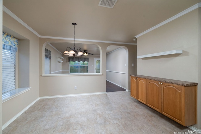 2392 Medina, New Braunfels, TX 78130 - unfurnished dining area featuring arched walkways, a chandelier, baseboards, and crown molding