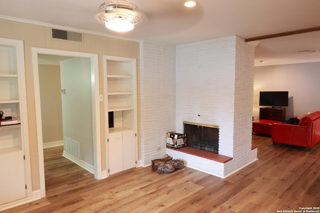 215 Five Oaks, San Antonio, TX 78209 - living area with crown molding, built in shelves, wood finished floors, a brick fireplace, and baseboards