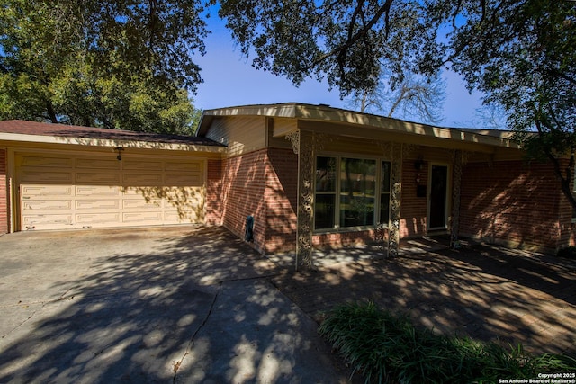 215 Five Oaks, San Antonio, TX 78209 - view of front of home featuring brick siding, concrete driveway, and a garage
