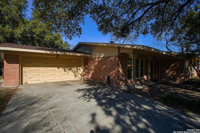 215 Five Oaks, San Antonio, TX 78209 - view of front of house with brick siding, concrete driveway, and an attached garage