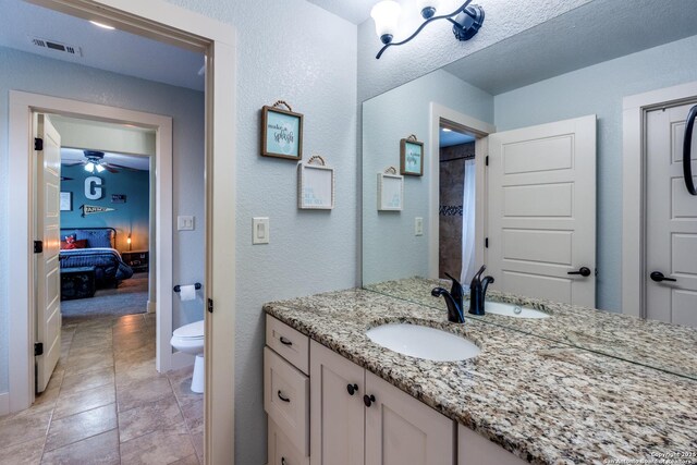 24435 Canyon Row, San Antonio, TX 78260 - full bath with toilet, vanity, a textured wall, ensuite bathroom, and ceiling fan