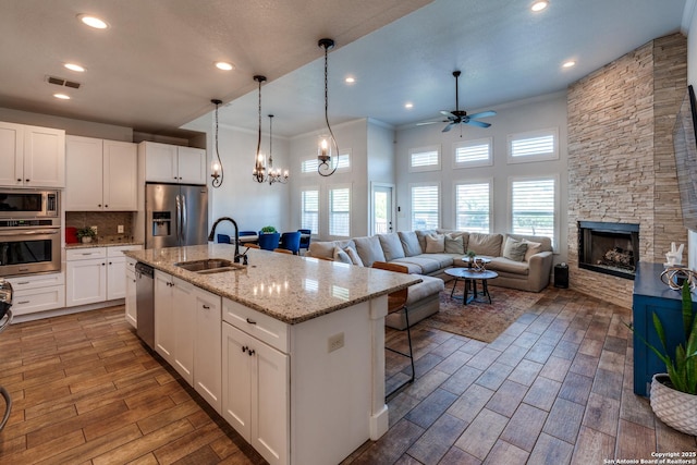 24435 Canyon Row, San Antonio, TX 78260 - kitchen with stainless steel appliances, a sink, a ceiling fan, crown molding, and wood finished floors