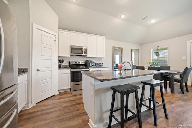 6907 Emerald Vly, San Antonio, TX 78242 - kitchen featuring stainless steel appliances, a sink, lofted ceiling, a center island with sink, and a breakfast bar