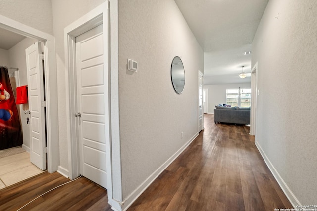 6907 Emerald Vly, San Antonio, TX 78242 - hallway with wood finished floors, a textured wall, and baseboards