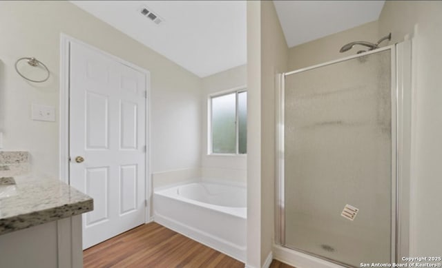 4039 Privet, San Antonio, TX 78259 - bathroom with a stall shower, wood finished floors, a bath, and double vanity