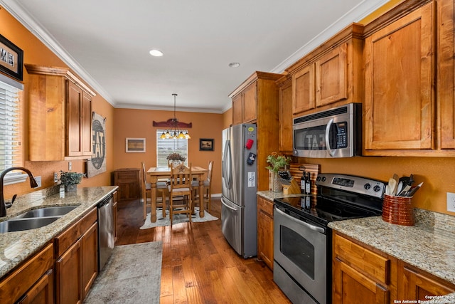 1355 Lasso, Canyon Lake, TX 78133 - kitchen with stainless steel appliances, a sink, a chandelier, brown cabinetry, and wood-type flooring