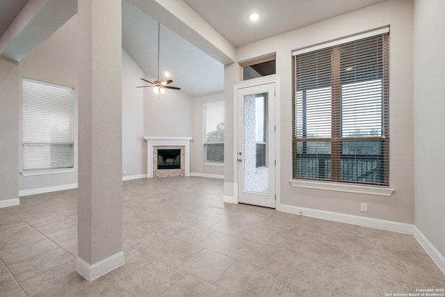 25448 River Ledge, San Antonio, TX 78255 - unfurnished living room featuring healthy amount of natural light, ceiling fan, lofted ceiling, light tile patterned floors, and a fireplace