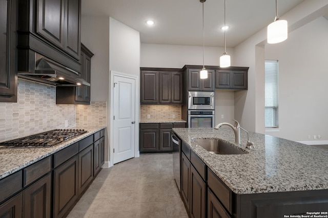 25448 River Ledge, San Antonio, TX 78255 - kitchen featuring appliances with stainless steel finishes, a sink, a center island with sink, dark brown cabinetry, and hanging light fixtures