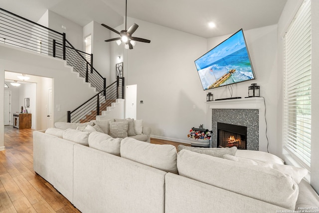 375 Sonata Cyn, Spring Branch, TX 78070 - living area featuring light wood-style floors, a tile fireplace, a high ceiling, a ceiling fan, and baseboards