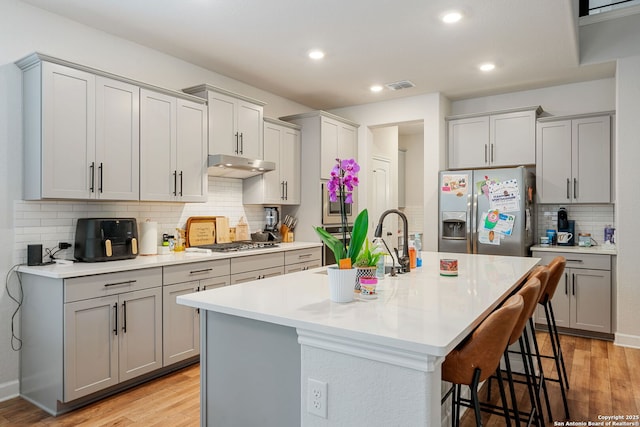 375 Sonata Cyn, Spring Branch, TX 78070 - kitchen featuring appliances with stainless steel finishes, gray cabinetry, under cabinet range hood, tasteful backsplash, and recessed lighting