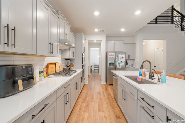 375 Sonata Cyn, Spring Branch, TX 78070 - kitchen featuring a sink, under cabinet range hood, light wood-type flooring, stainless steel appliances, and light countertops