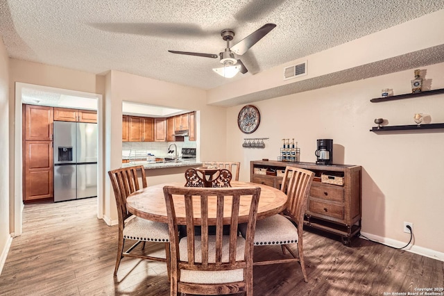 8517 Echo Crk, San Antonio, TX 78240 - dining area with wood finished floors, ceiling fan, baseboards, and a textured ceiling