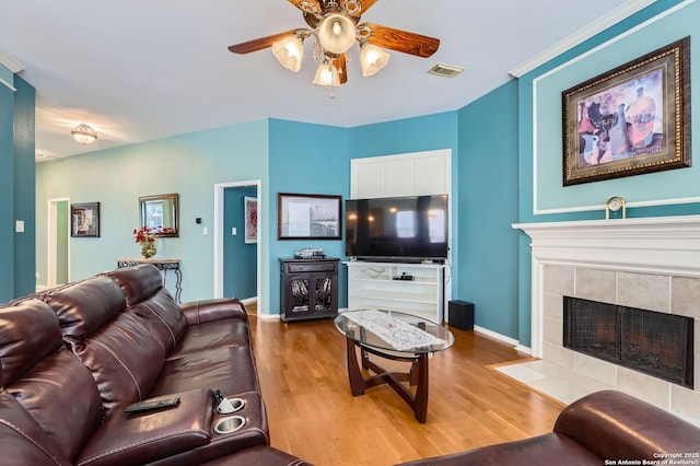 1730 Escada, San Antonio, TX 78258 - living room with a ceiling fan, light wood finished floors, baseboards, and a tile fireplace