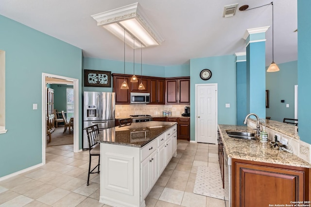 1730 Escada, San Antonio, TX 78258 - kitchen featuring stainless steel appliances, a kitchen island, a kitchen breakfast bar, a sink, and backsplash