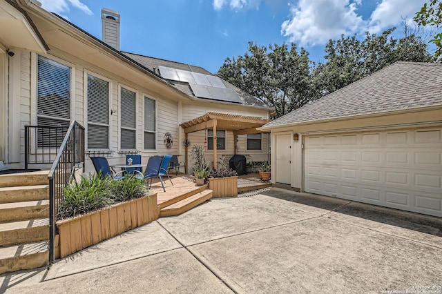 1730 Escada, San Antonio, TX 78258 - view of property exterior featuring a garage, a chimney, solar panels, and driveway