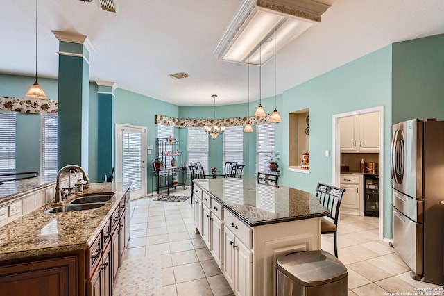 1730 Escada, San Antonio, TX 78258 - kitchen featuring freestanding refrigerator, a sink, an island with sink, and light tile patterned floors