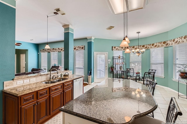 1730 Escada, San Antonio, TX 78258 - kitchen with a sink, a kitchen island with sink, stainless steel dishwasher, brown cabinetry, and stone countertops