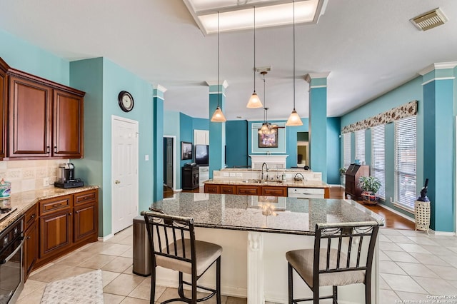 1730 Escada, San Antonio, TX 78258 - kitchen featuring stainless steel oven, a sink, a kitchen island with sink, and light tile patterned floors