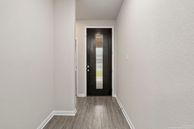 3065 Charyn Way, New Braunfels, TX 78132 - doorway to outside featuring wood finished floors, baseboards, and a textured wall
