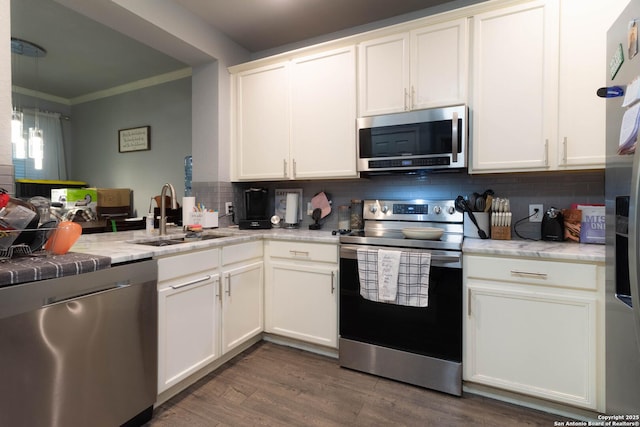 2547 Grayson, San Antonio, TX 78232 - kitchen with appliances with stainless steel finishes, a sink, crown molding, backsplash, and white cabinets