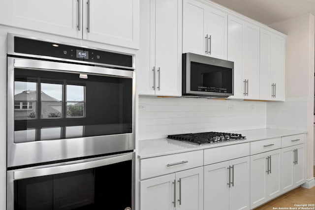 3082 Bright Skies, San Antonio, TX 78261 - kitchen with appliances with stainless steel finishes, light countertops, white cabinetry, and tasteful backsplash