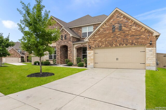 3082 Bright Skies, San Antonio, TX 78261 - view of front facade with driveway, stone siding, a front yard, and brick siding