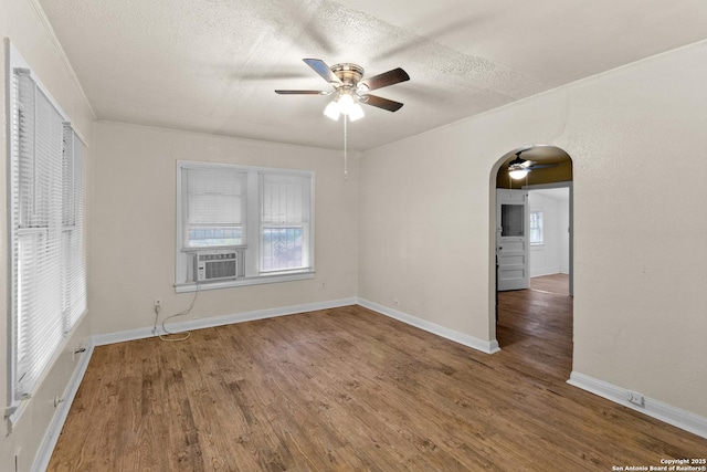 1001 Mason, San Antonio, TX 78208 - spare room featuring a ceiling fan, wood finished floors, a textured ceiling, cooling unit, and arched walkways