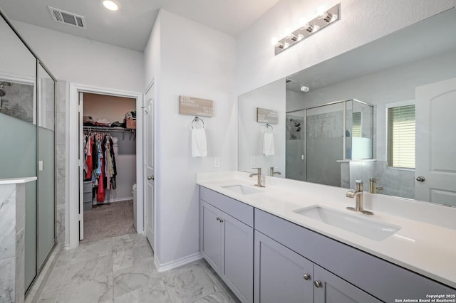 14468 Gecko Lndg, San Antonio, TX 78253 - bathroom with a shower stall, marble look tile flooring, a walk in closet, double vanity, and baseboards