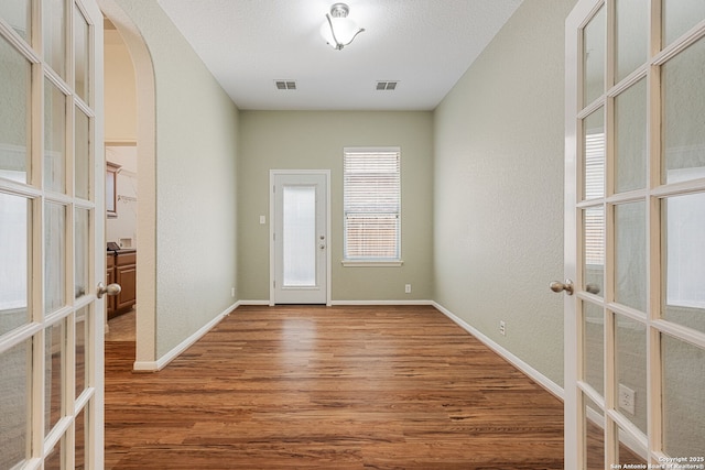 1210 Magellan, Windcrest, TX 78239 - foyer with french doors, wood finished floors, arched walkways, a textured wall, and baseboards