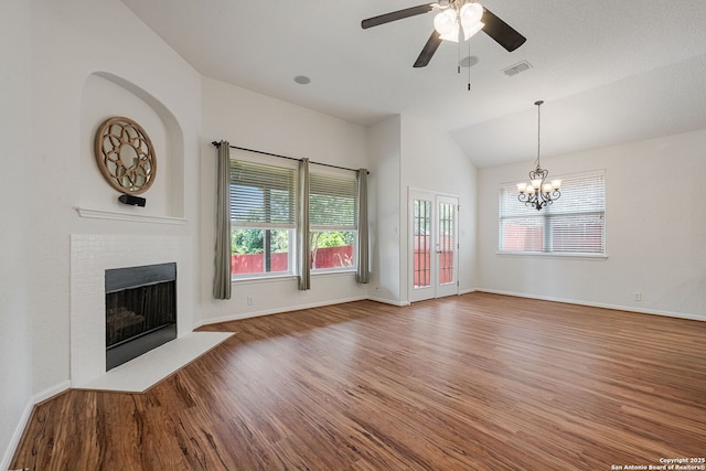 1210 Magellan, Windcrest, TX 78239 - unfurnished living room with vaulted ceiling, wood finished floors, a fireplace, healthy amount of natural light, and a chandelier