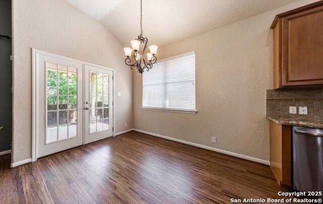 1210 Magellan, Windcrest, TX 78239 - unfurnished dining area with french doors, dark wood-style floors, a chandelier, lofted ceiling, and baseboards