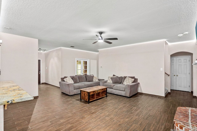 4222 Manitou Bay, San Antonio, TX 78259 - living room featuring arched walkways, a ceiling fan, dark wood-type flooring, a textured ceiling, and baseboards