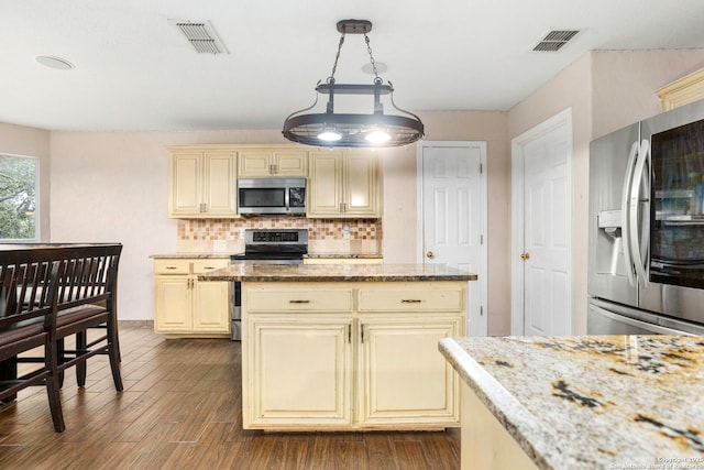 4222 Manitou Bay, San Antonio, TX 78259 - kitchen featuring stainless steel appliances, cream cabinets, light stone counters, and backsplash