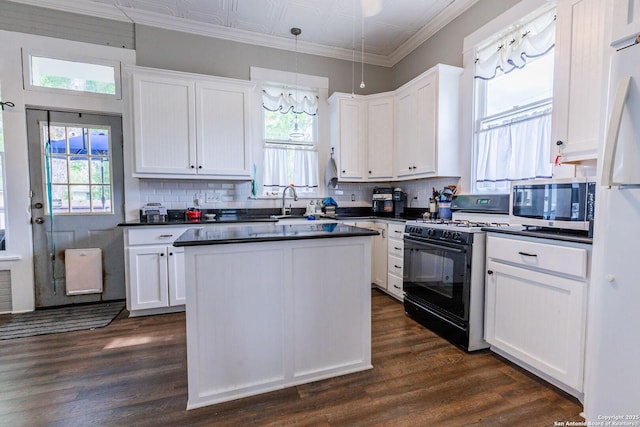 225 W Humphreys, Seguin, TX 78155 - kitchen with black range with gas cooktop, stainless steel microwave, dark countertops, and ornamental molding