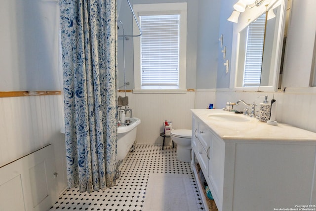 225 W Humphreys, Seguin, TX 78155 - bathroom with a wainscoted wall, a freestanding bath, vanity, a shower with curtain, and toilet