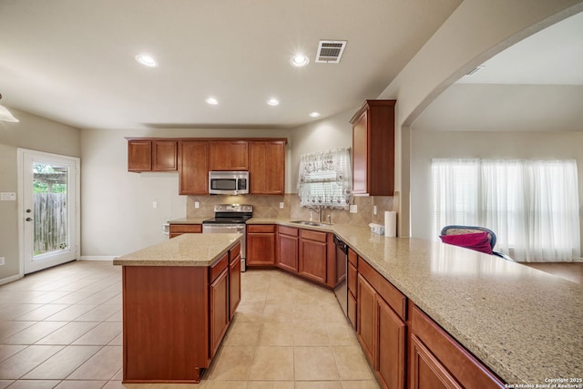 7459 Eagle Ledge, San Antonio, TX 78249 - kitchen with appliances with stainless steel finishes, arched walkways, tasteful backsplash, brown cabinetry, and recessed lighting