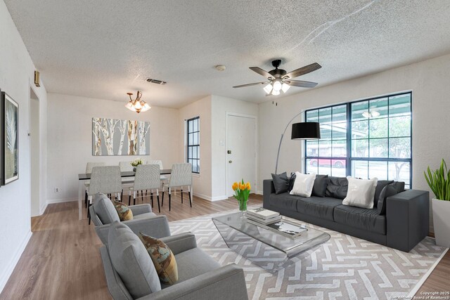 118 Elkins, San Antonio, TX 78226 - living area with light wood-type flooring, ceiling fan, a textured ceiling, baseboards, and a chandelier