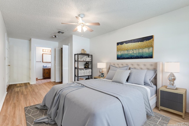 118 Elkins, San Antonio, TX 78226 - bedroom featuring light wood-style flooring, a textured ceiling, baseboards, ceiling fan, and connected bathroom
