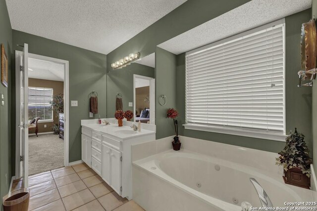 821 Lakeview, Canyon Lake, TX 78133 - bathroom with ensuite bathroom, a tub with jets, a textured ceiling, tile patterned flooring, and double vanity