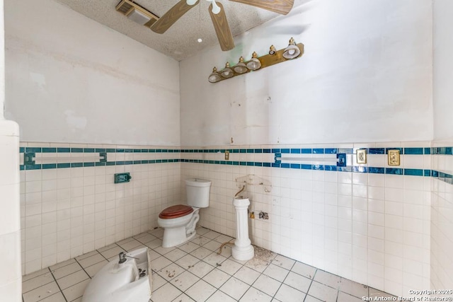 3311 W Commerce St, San Antonio, TX 78228 - bathroom featuring a bidet, a ceiling fan, tile walls, toilet, and a wainscoted wall